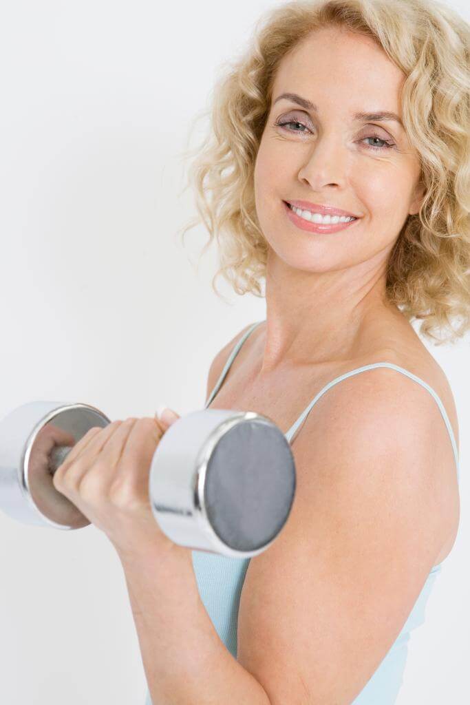 Smiling woman with a dumbbell